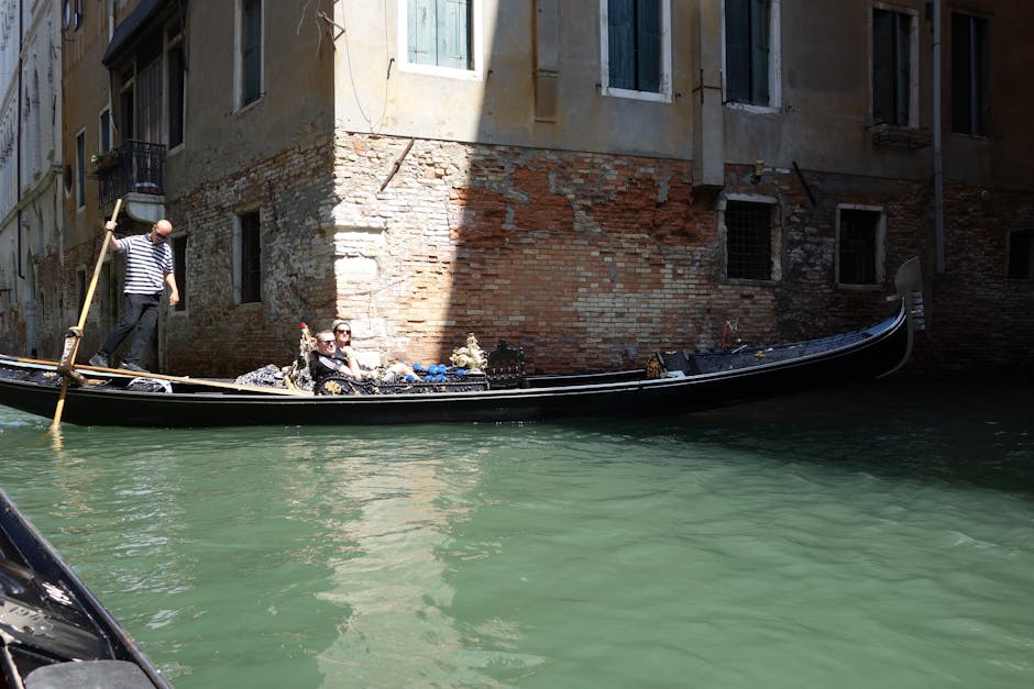 couple enjoying a gondola ride through the canals of Venice - 30 year anniversary trip ideas